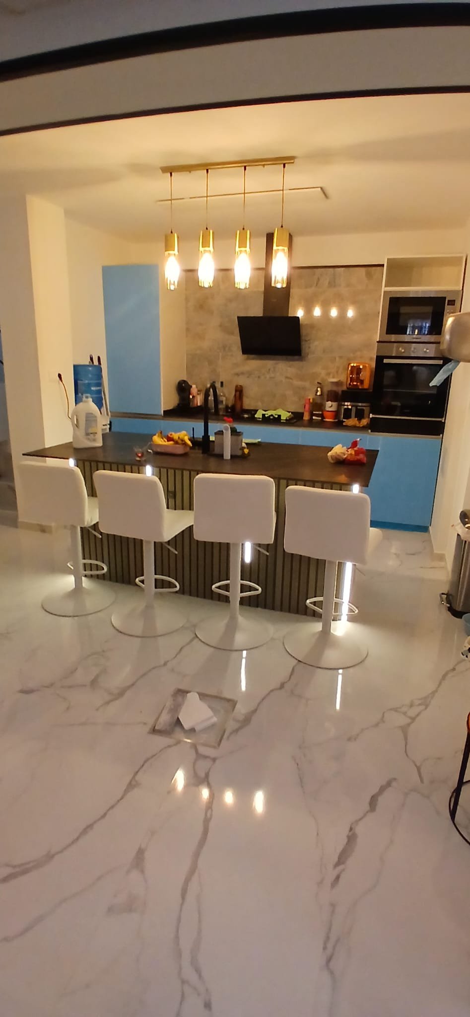 Cocina abierta reformada con barra y taburetes en Madrid
